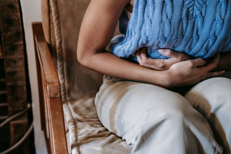 Cirujano general examinando el abdomen de un paciente en consultorio médico