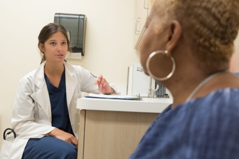 Médico clínico atendiendo a un paciente adulto en un consultorio