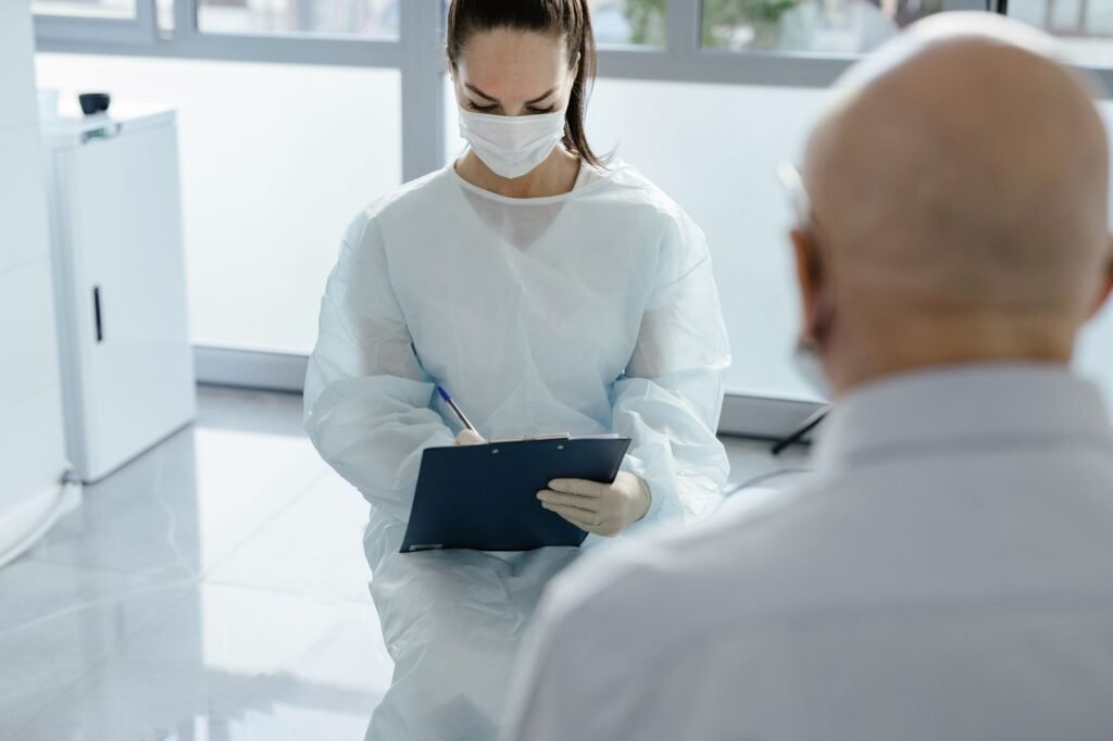 Médico traumatólogo examinando la rodilla de un paciente en el consultorio