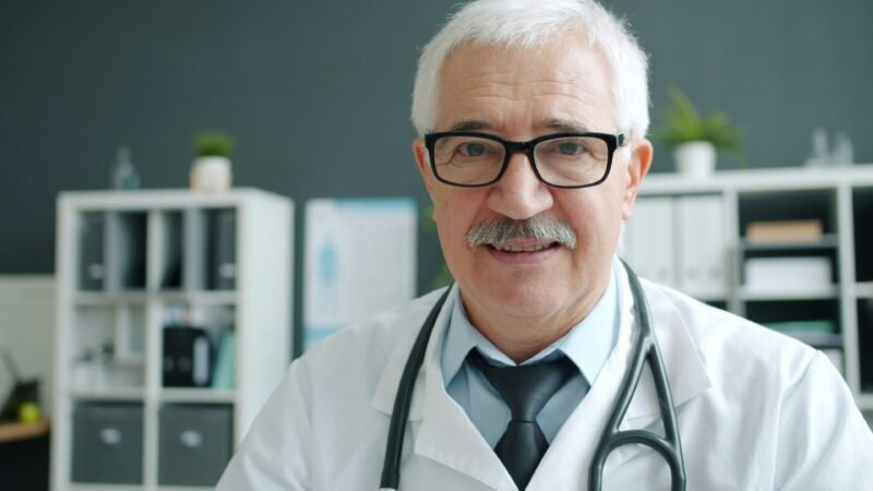 Persona buscando información sobre la matrícula de un médico en el sitio web de un colegio médico provincial desde su computadora