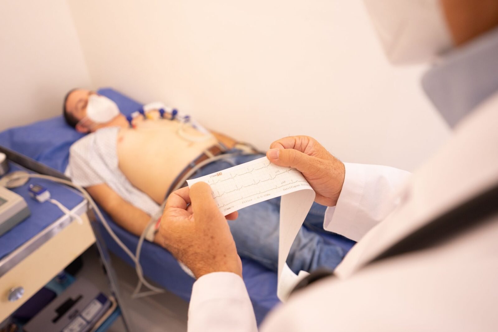 Cirujano cardiovascular revisando estudios cardíacos con un paciente en consultorio