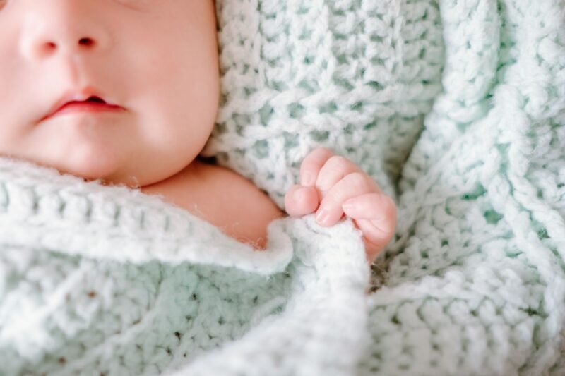 Pediatra revisando a un recién nacido mientras la mamá observa en el consultorio